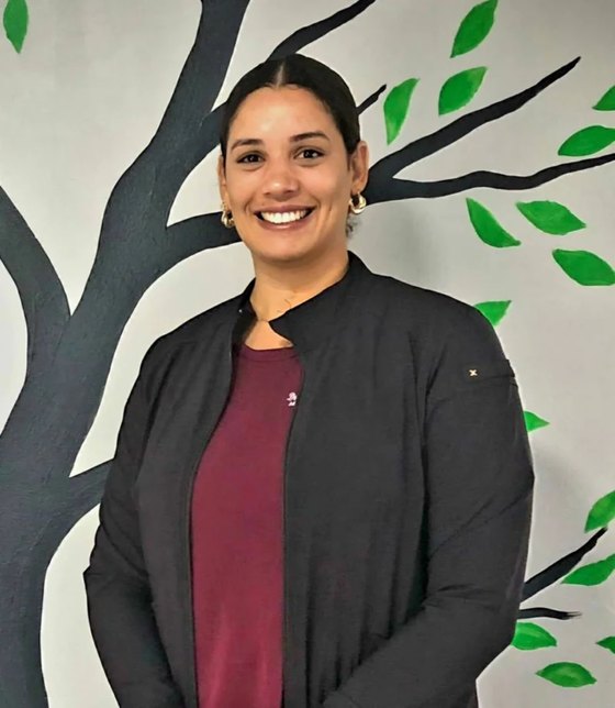 Doctor Rosi, standing in front of the clinic's tree mural.